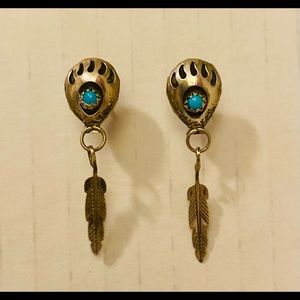 Dangling silver stud with turquoise center with a small silver feather.